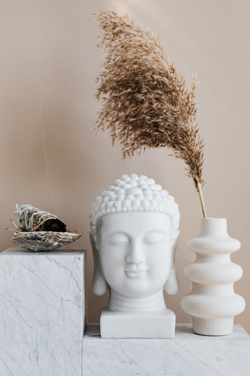 vase with dried herb arranged with buddha bust and sage smudge stick in bowl